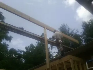 Carpenter setting a ridge beam over a new addition frame — Ice Dam Removal by Roofing Brothers in Sarahsville