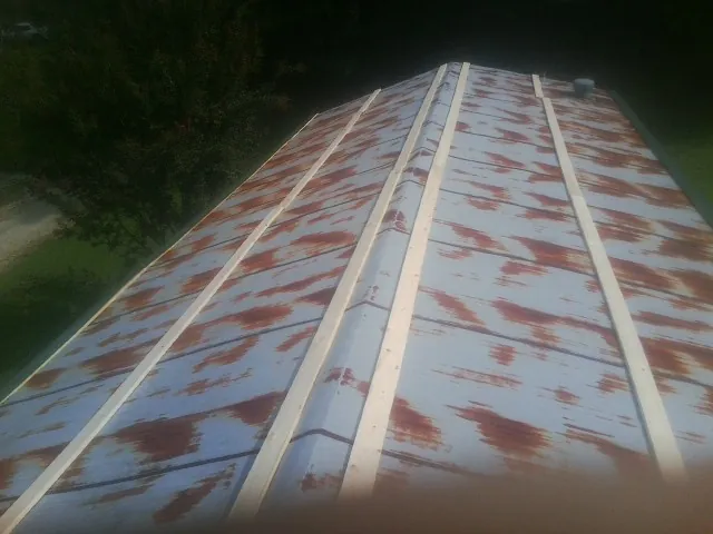 Rusted metal roof panels with new wood purlins before replacement — Storm Damage Roof Repair in Sarahsville by Roofing Brothers