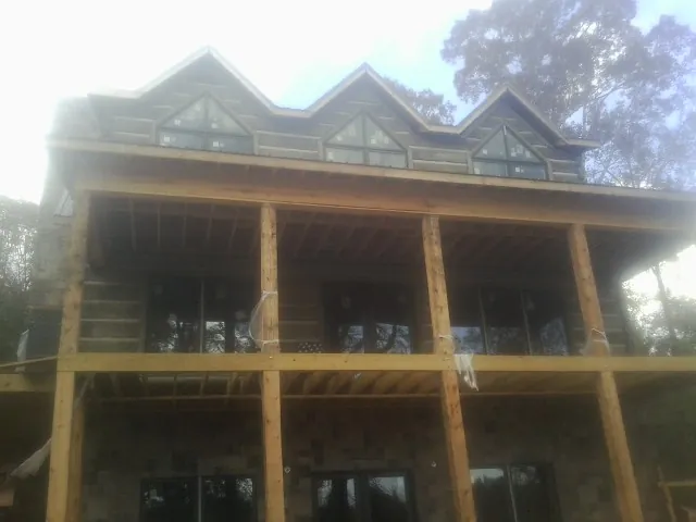 Dormers and porch framing on a large log home under construction — Roof Coating work by our crew in Sarahsville