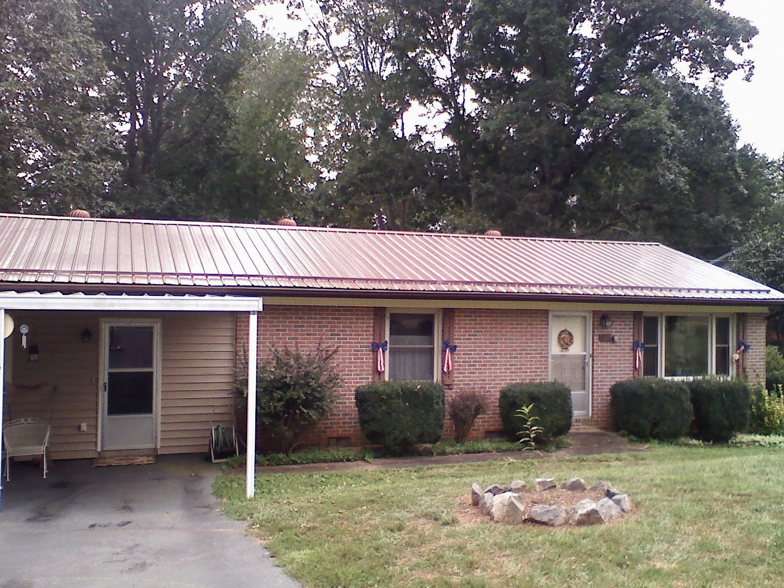 Bronze metal roof and carport on a brick ranch home — Roof Repair work by our crew in Sarahsville